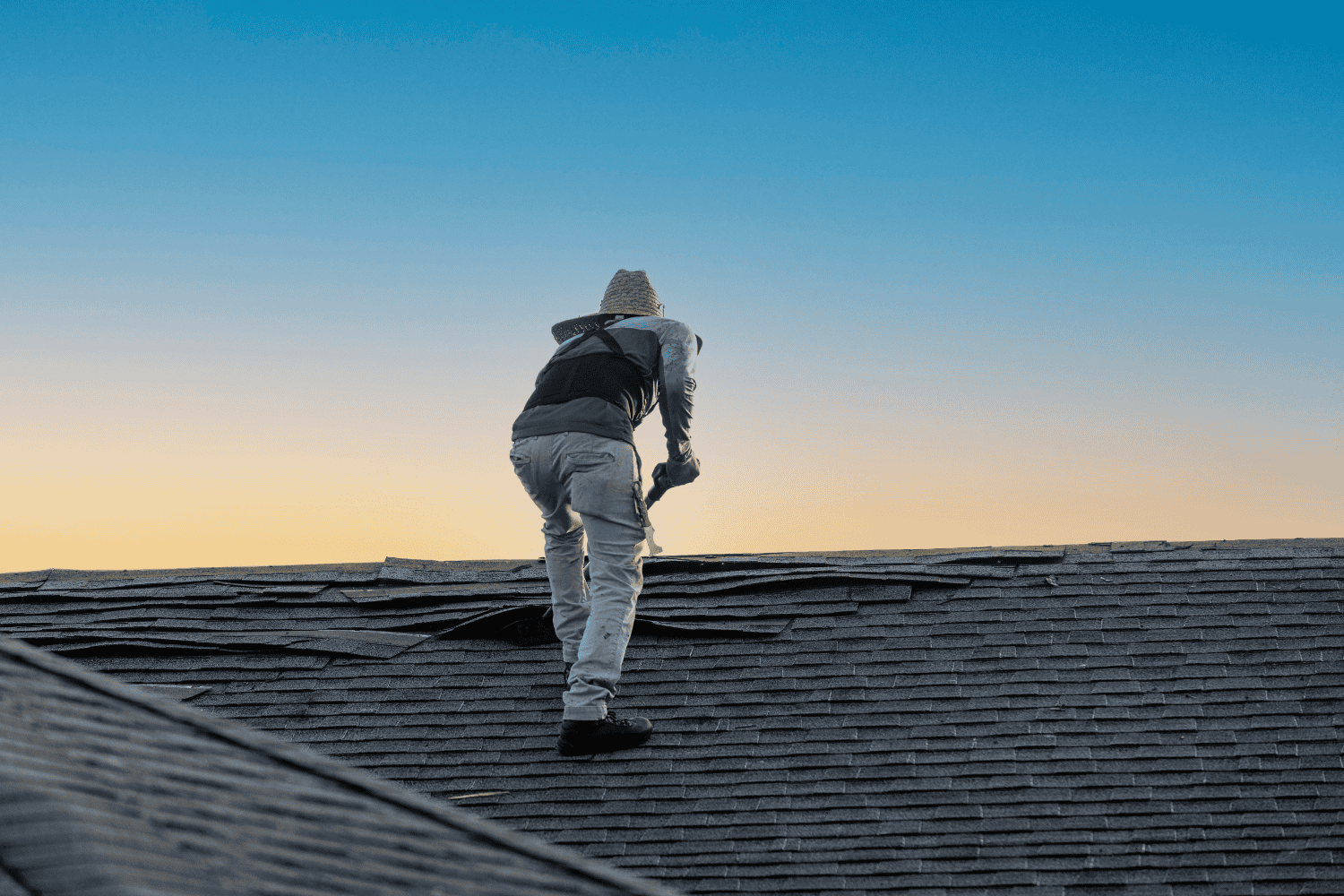 A professional roofing contractor inspecting a roof for damage.