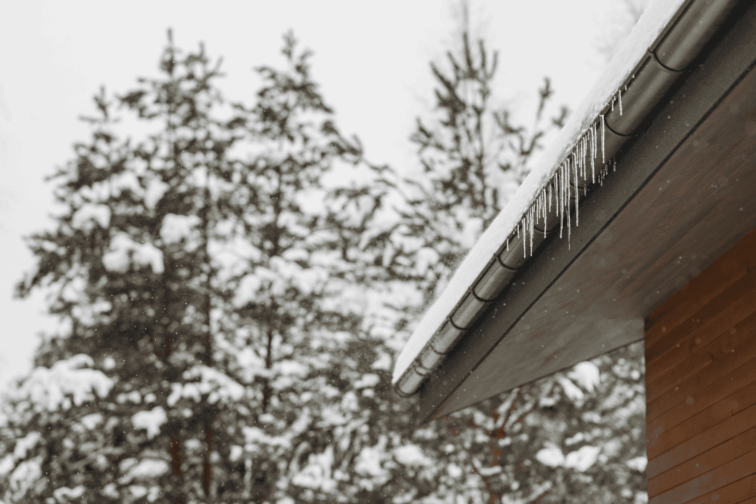 Icicles hanging from a roof, showcasing the formation of ice dams.